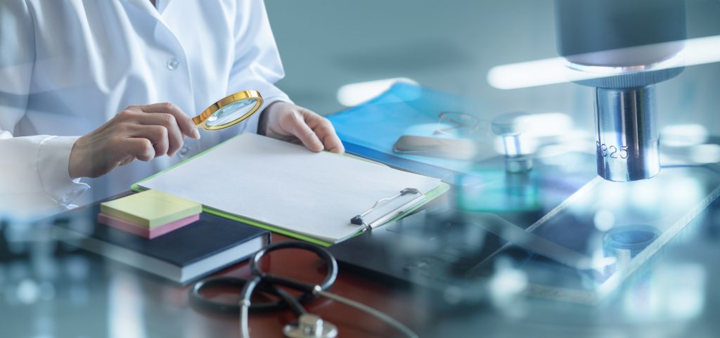 Doctor studying a document against a blurred background .